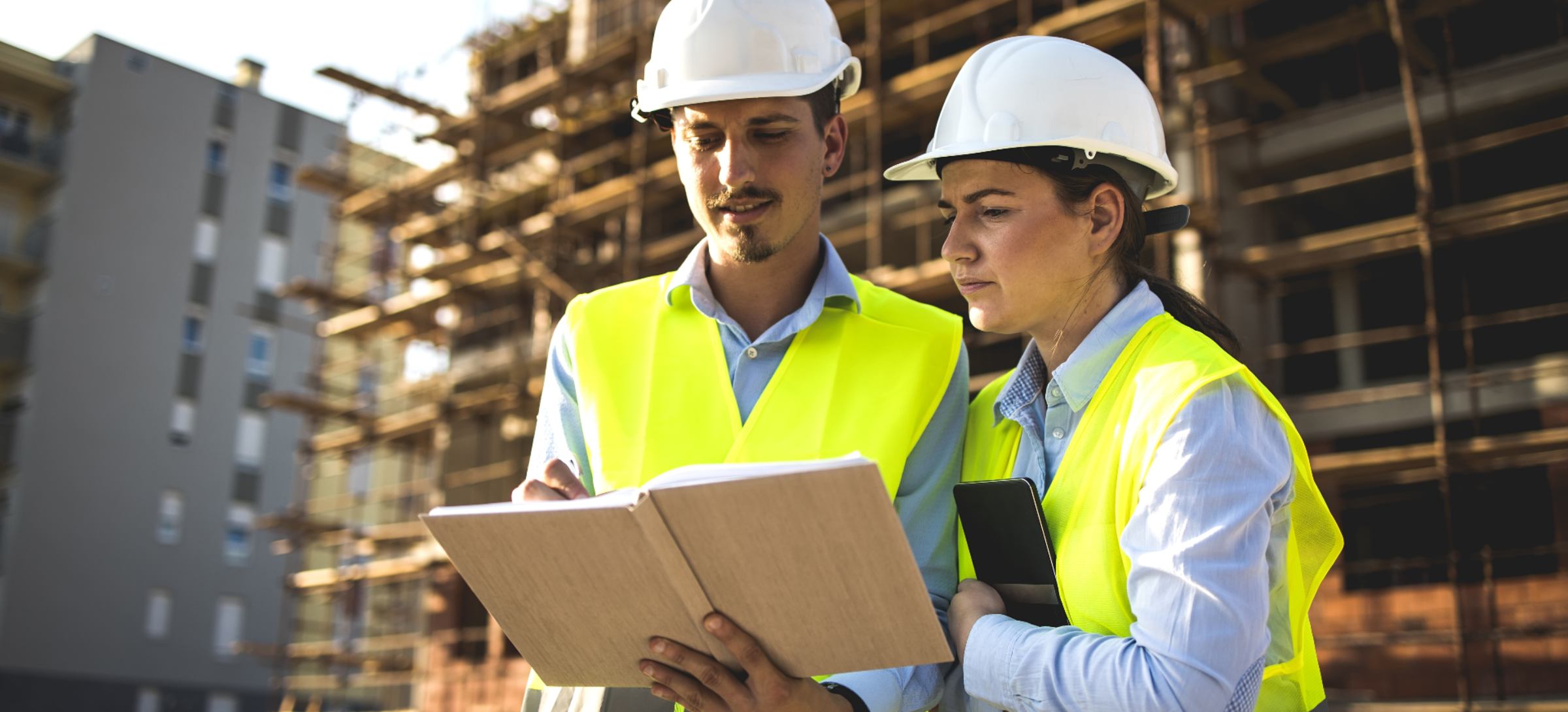 Deux salariés du bâtiment échangent sur un projet de construction